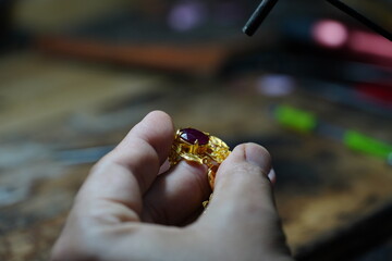 Thai jeweler, handles the jewelry and precious stones in the workshop, the process of jewelry making ,close-up