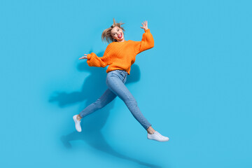 Fototapeta na wymiar Full length profile photo of lovely overjoyed person jump rush empty space isolated on blue color background