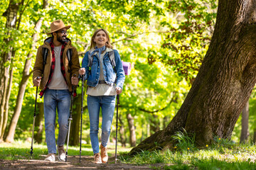 Obraz premium Young couple with scandinavian sticks walking and talking