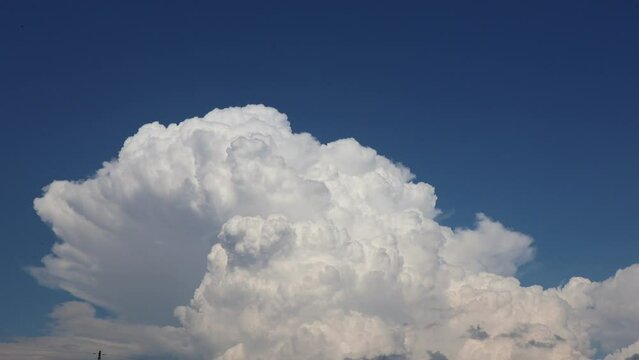 Time lapse of white fluffy cumulus clouds against a blue sky. 4k video of natural skyscape