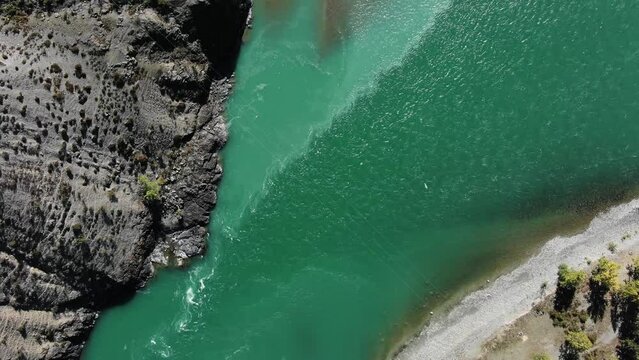 Confluence of two fast mountain rivers with turquoise water, aerial view