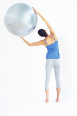 Fototapeta premium Woman, exercise or ball with back for yoga, exercise or workout on muscle, posture and healthy body. Person, arm or stretching for pilates, training or fitness with sportswear and technique in studio