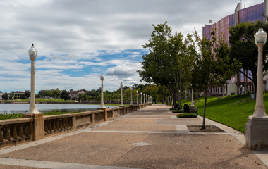 Obraz premium Trees and light posts along walking promenade of Lake Mirror in Lakeland, Florida