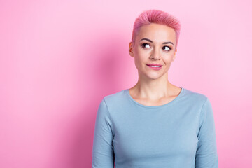 Photo of tricky thoughtful lady wear blue shirt biting lip looking empty space isolated pink color...