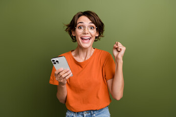 Portrait of overjoyed impressed person wear stylish t-shirt eyewear holding smartphone win betting...