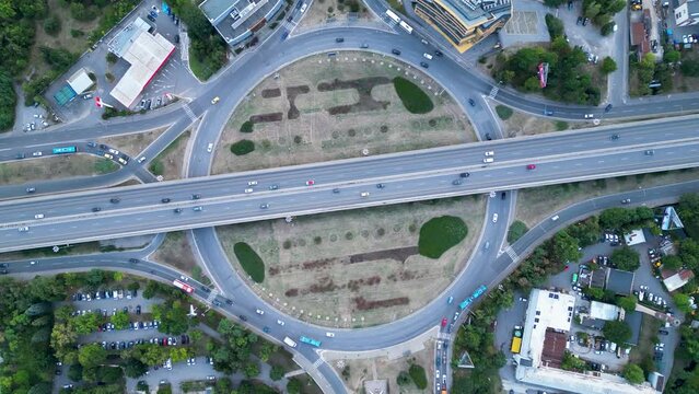 4k Aerial high angle footage of a multy level intersection with roundabout in Sofia Bulgaria. The Fourth kilometer interchange junction.Traffic flowing during rush hour in a city.
