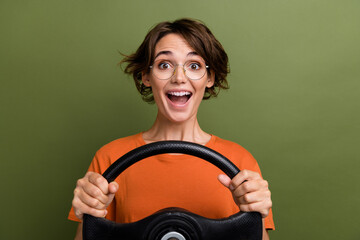 Photo of young crazy funky positive girl holding steering wheel learning how to drive on road...