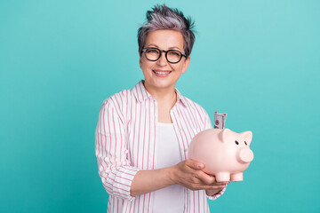 Photo of successful family lady grey dyed short haircut hold piggy bank collect money for dream...