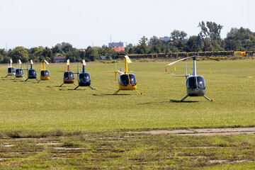 Helicopters, Robinson (R44) on grass airfield - obrazy, fototapety, plakaty
