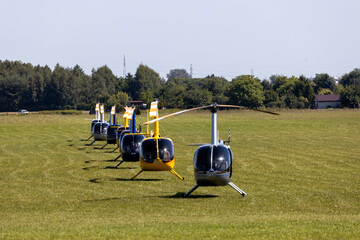 Helicopters, Robinson (R44) on grass airfield - obrazy, fototapety, plakaty
