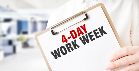 Text 4 day work week on white paper plate in businessman hands in office. Business concept