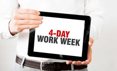 Text 4 day work week on tablet display in businessman hands on the white background. Business...
