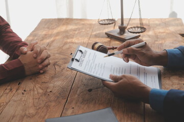Justice and Law concept. Legal counsel presents to the client a signed contract with gavel and...