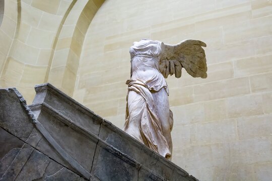 Louvre museum, Paris, France. Winged Victory of Samothrace or Nike of Samothrace at the top of the main staircase, since 1884. Marble sculpture from the Hellenistic period.