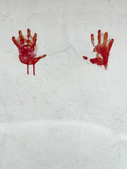bloody red hands print on white wall