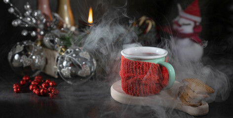 Decorating a Christmas composition with deer and a hot drink on a background, a place to copy and mug with splashes and drops of hot mulled wine at romantic moment