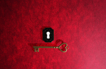 Vintage gold key with heart shaped top and ornate lock on red background