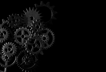 Assorted mechanical gears on black background with copy space