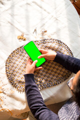 Woman holding smartphone with green screen 