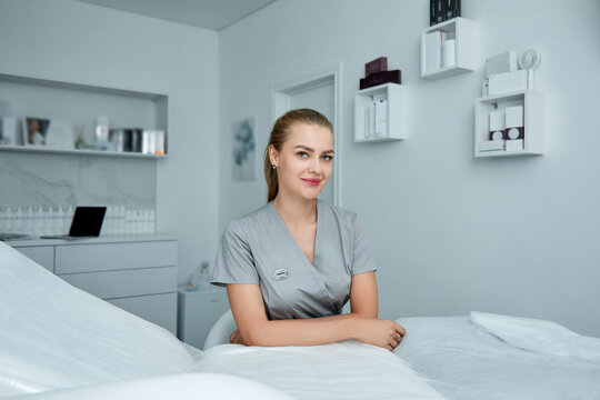 Young beautiful cosmetologist in cosmetology cabinet