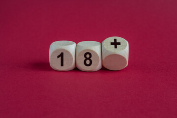 Symbol for a age limit. Dice form the expression 18 +. Beautiful red background. Copy space.
