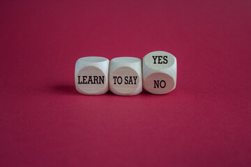 Turned a cube and changes the expression learn to say yes to learn to say no. Beautiful red background. Copy space.