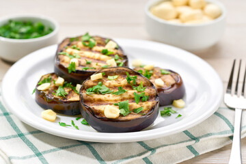 Salad with grilled eggplant, parsley and garlic on a white plate,selective focus.