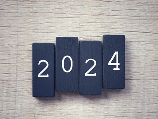 New Year Celebration Concept. Figure 2024 written on wooden blocks. With blurred styled background.