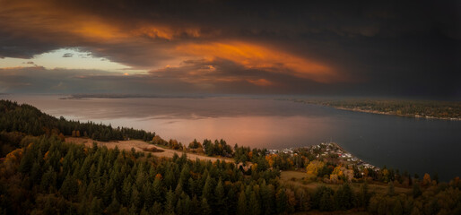 Dramatic sunrise over the east side of Lummi island, Washington. The small island community, called Lane Spit, is illuminated by the beautiful morning light on this fall day in the Pacific Northwest.