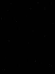 Festive vector background with gold glitter and confetti for christmas celebration. Black background with glowing golden particles.