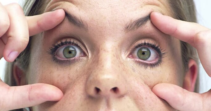 Hands, open eyelid and tired face for woman, check vision or health with retina exam for wellness. Person, eyes and stretching for test, fatigue and burnout with fingers, skin and pupil in closeup