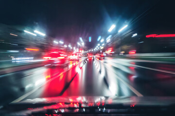 Night rainy highway. High-speed traffic and blur on a long exposure. Neon lights of city.