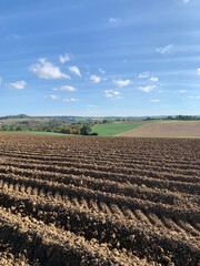 A plowed field with furrows against a blue sky in sunny weather in Germany. State of Baden-Württemberg