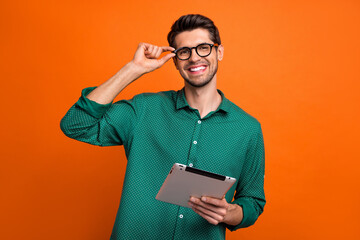 Photo of positive good mood man dressed green shirt texting instagram twitter telegram facebook isolated orange color background