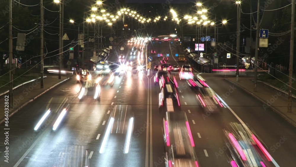 Wall mural kyiv, ukraine - october, 2023. timelapse. cars driving fast through city at night in rays of street 