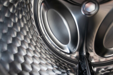 View into washing machine drum inside with stainless steel drum interior shows household equipment...