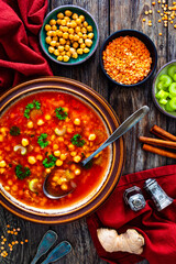 Moroccan cuisine - harira fresh vegetable soup with chickpeas and lentil on wooden table

