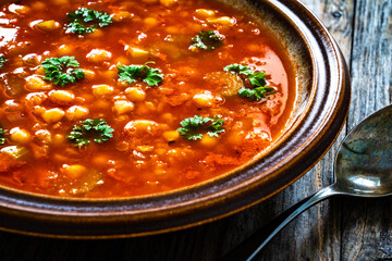 Moroccan cuisine - harira fresh vegetable soup with chickpeas and lentil on wooden table

