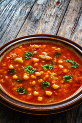 Moroccan cuisine - harira fresh vegetable soup with chickpeas and lentil on wooden table

