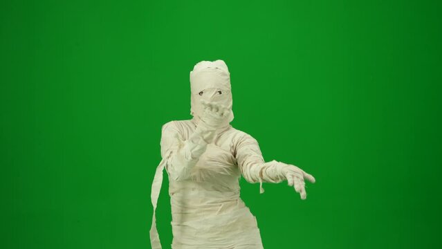 Scary mummy wrapped in bandages dancing the Macarena dance. Green screen isolated chroma key. Mock up, workspace for your promotion clip or advertisement. Medium size.