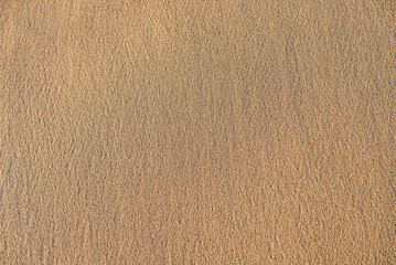 Close-up of smooth wet sand at a beach. Texture, background.