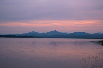 Sunset in Gabriel y Galan reservoir with mountains in the background and silky water