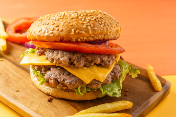 Homemade burger with two meats, cheese, lettuce, tomato and onion