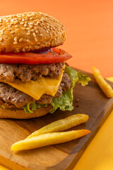 Homemade burger with two meats, cheese, lettuce, tomato and onion