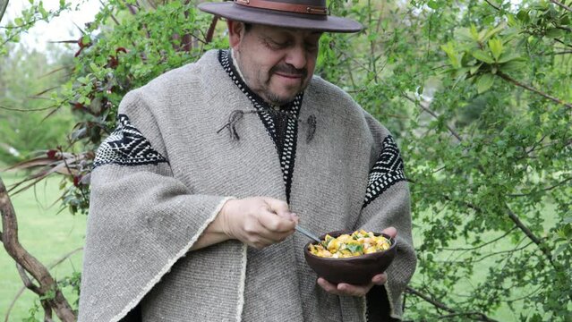 Front view of country mapuche man, eating and tasting diguenes, cyttaria espinosae, edible mushroom in the countryside
