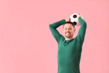 Fototapeta premium Happy man with soccer ball on pink background