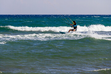 Man practicing kitesurfing on the waves