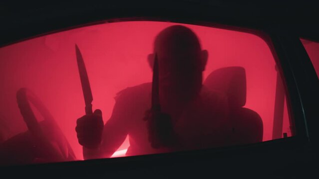 Halloween killer with knife inside the car
