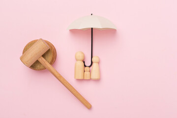 Wooden family figures with judge's gavel on color background,top view