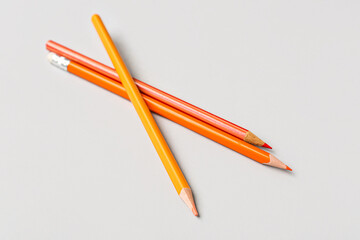 Three colorful pencils on light background